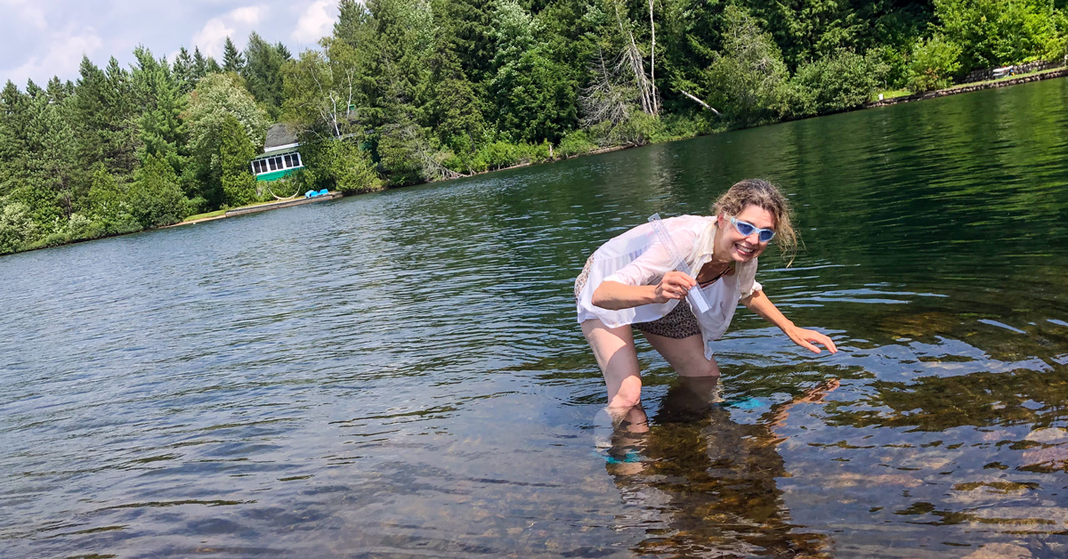 Une femme prend des mesures de périphyton dans un lac.